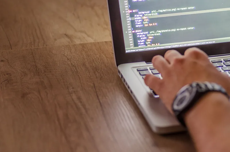 Developer writing integration code for a website checkout on a laptop