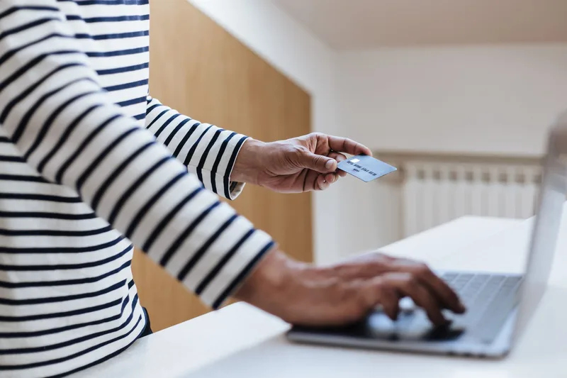 Malaysian ecommerce merchant comparing BNPL payment providers on a laptop, reviewing Atome and GrabPay PayLater merchant terms