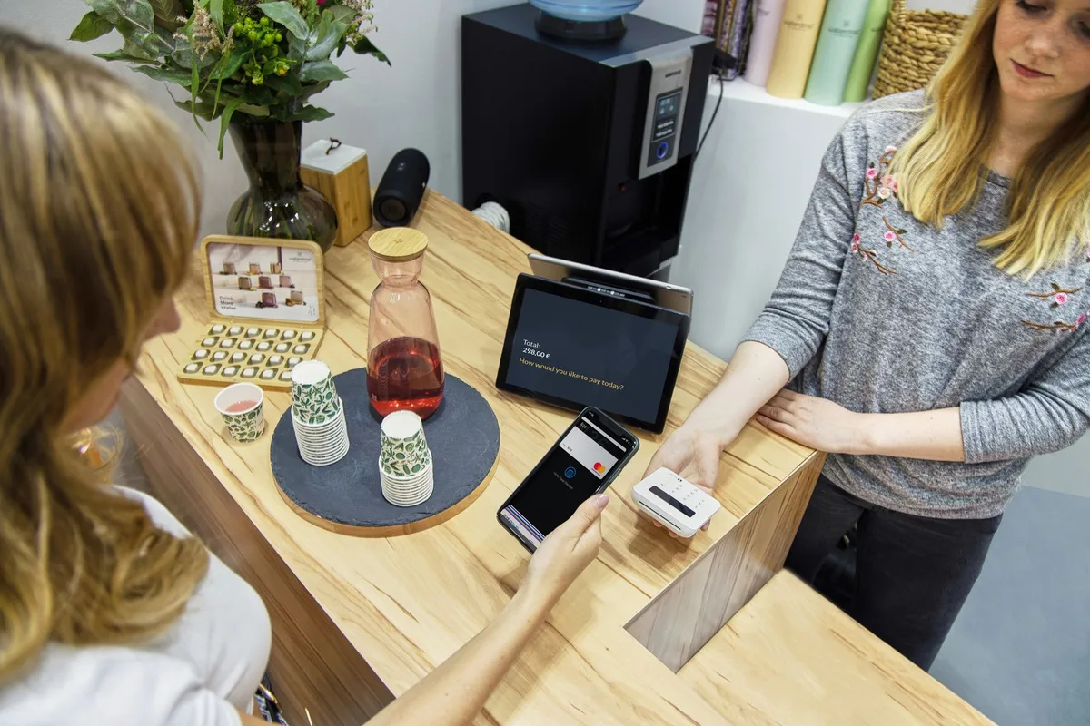 Ecommerce merchant completing a contactless payment checkout at a modern retail terminal