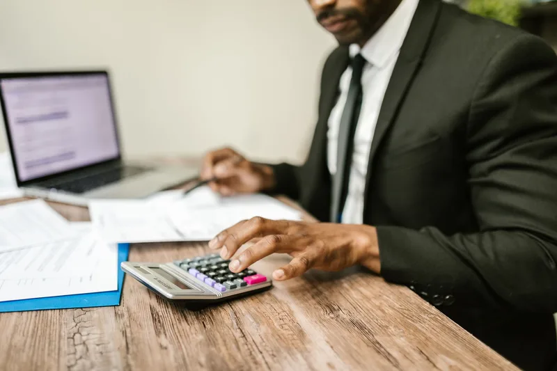 UAE business owner calculating payment gateway costs at a desk with financial documents